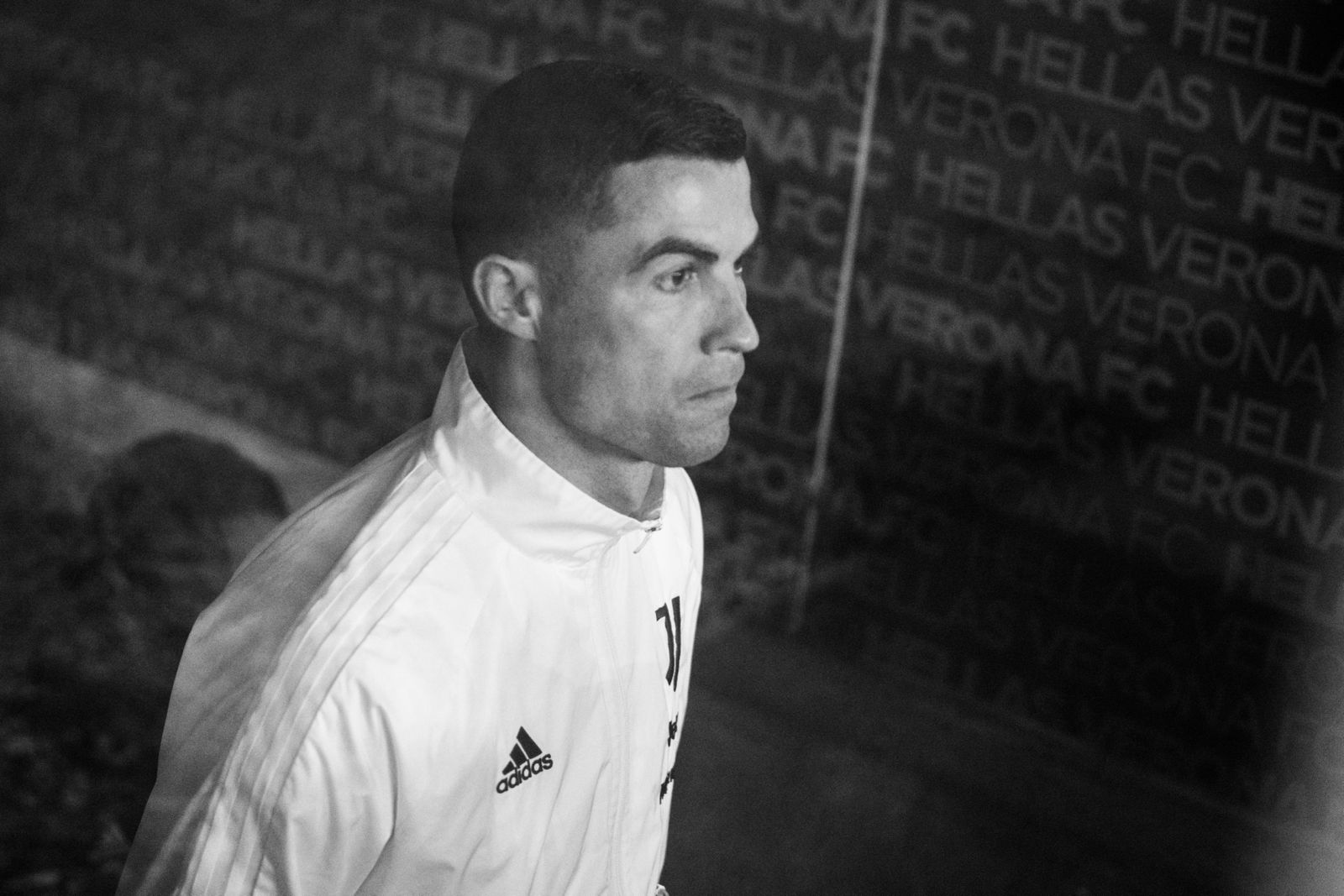 Fotografia sportiva in bianco e nero, calciatore nel tunnel dello stadio Hellas Verona FC prima della partita, reportage calcistico professionale.