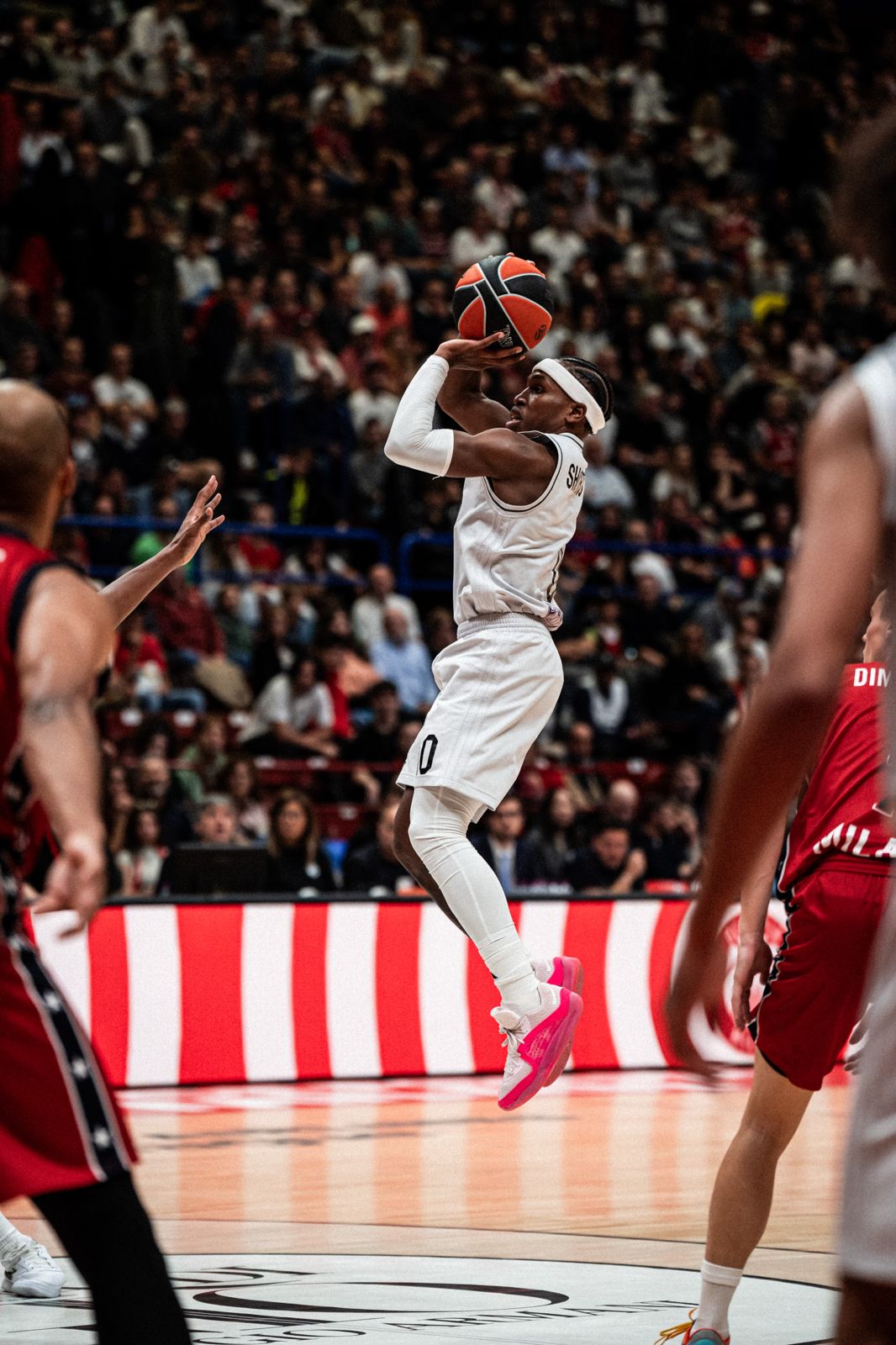 iocatore di basket in elevazione verso il canestro, fotografato con luce dinamica